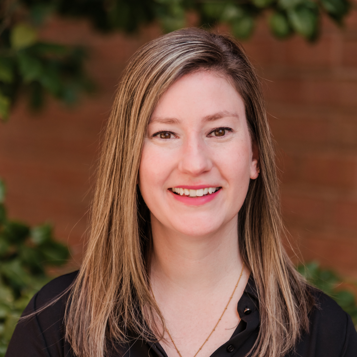 Professional portrait of a smiling woman with long hair