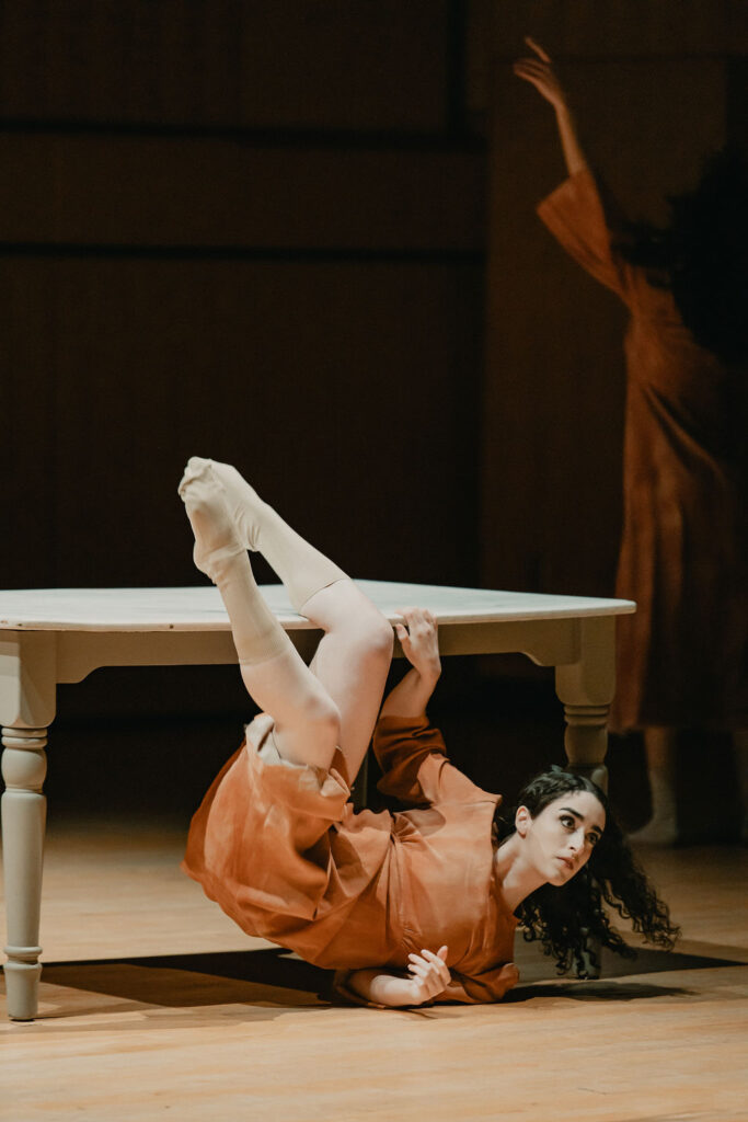 a woman interacts with a table in a dance